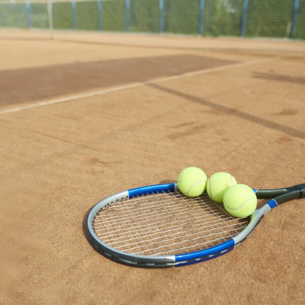 Tennis balls and tennis racket on the foreground